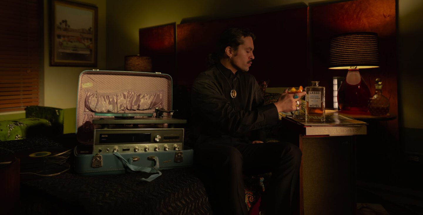 Man sitting on bed in hotel room